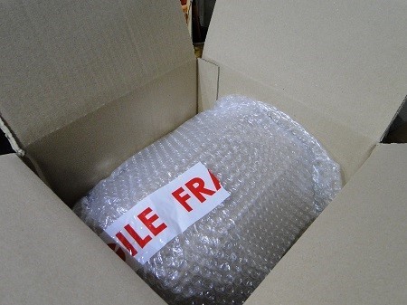 Posez les haut-parleurs dans le carton sur une couche de polystyrene